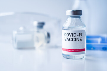 A single bottle vial of Covid-19 vaccine. Medical concept vaccination hypodermic injection...