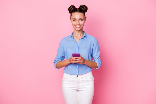 Back view photo portrait of female influencer holding mobile phone texting typing comment isolated on pastel pink color background