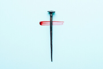 Christian cross made with rusty nails, drops of blood on blue background. Copy space. Good Friday,...