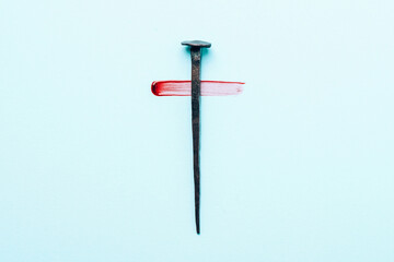 Christian cross made with rusty nails, drops of blood on blue background. Copy space. Good Friday, Easter day. Christian backdrop. Biblical faith, gospel, salvation concept. Jesus Christ Crucifixion