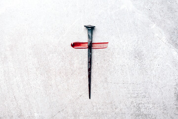 Christian cross made with rusty nails, drops of blood on grey background. Copy space. Good Friday,...
