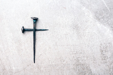 Cross made with rusty nails and drops of blood on grey background. Copy space. Good Friday, Easter...