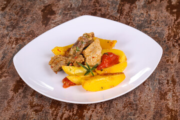 Baked pork meat with potao and tomato