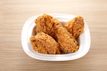crispy fried chicken in white dish on wood table