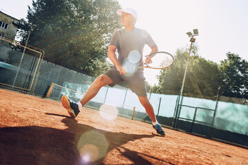 Middle-aged man playing tennis on outdoor tennis filed