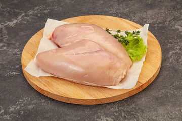 Raw chicken breast over board
