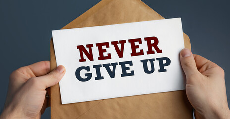 Male hands holding craft envelope with text NEVER GIVE UP on blue background