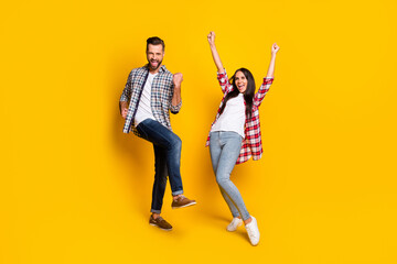 Full length photo portrait of excited crazy couple celebrating isolated on vivid yellow colored background