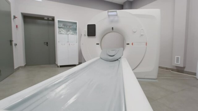 Handheld tracking shot of CT scan machine standing in radiology room of hospital