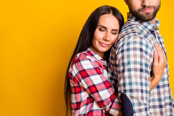 Fototapeta premium Photo portrait of woman hugging man from behind isolated on vivid yellow colored background with blank space