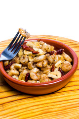 Prawns with garlic and cayenne in a ceramic bowl on a wooden tray