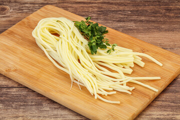 Chechil spaghetti cheese over board