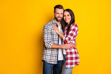 Naklejka premium Portrait of attractive cheerful sweet couple embracing spending time isolated over bright yellow color background