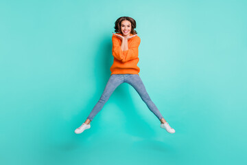 Fototapeta na wymiar Full size photo of young beautiful funky funny happy cheerful positive girl jumping isolated on turquoise color background