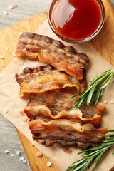 Concept of tasty snack with board of fried bacon