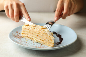 Woman eating delicious Napoleon cake, close up