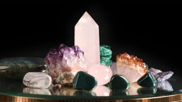 Set of different colorful semi-precious stones spinning on a black background

