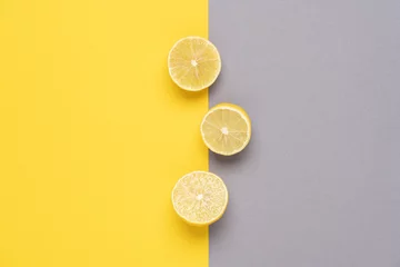 Farbe des Jahres Leuchtendes Gelb und Ultimate Grey. Gelbe Zitronen auf zweifarbigem Hintergrund © Anna Puzatykh