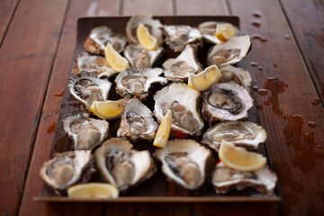 Fresh oysters with slices of lemon on the table. Fresh seafood.
