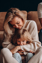 Young mother with her little daughter. Maternal love for a child. Studio photography.
