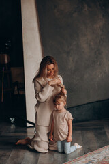 Fototapeta na wymiar Young mother with her little daughter. Maternal love for a child. Studio photography.