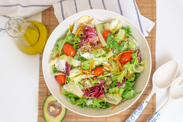 Top view of a salad with olive oil, avocado, vegetables and seeds