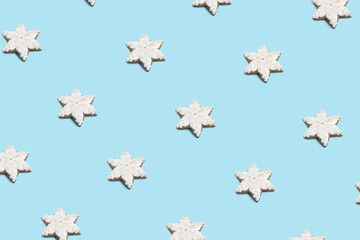 Creative minimal Christmas art. Pattern made with Christmas cookies on bright blue background. Flat lay. Copy space. Minimal composition.