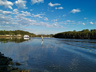 Beautiful view of a river with reflections of blue sky and trees on water, Parramatta river, Wilson Park, Silverwater, Sydney, New South Wales, Australia
