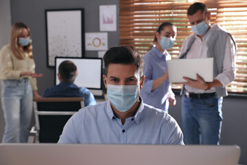 Worker with mask in office. Protective measure during COVID-19 pandemic