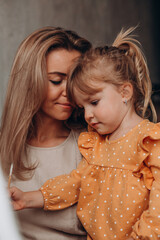 Young mother with her little daughter. Maternal love for a child. Studio photography.