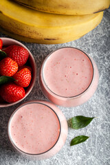 Fresh smoothie with banana and strawberry in the glasses. Healthy breakfast or snack. Top view.