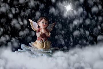 praying angel with snowflakes and star