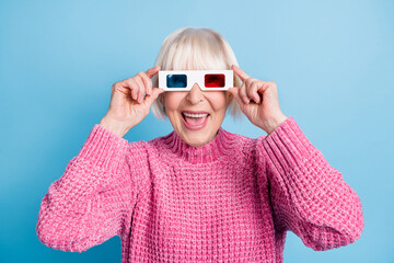 Photo portrait of excited old woman wearing 3d glasses touching with fingers isolated on pastel blue colored background