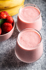 Fresh smoothie with banana and strawberry in the glasses. Healthy breakfast or snack.