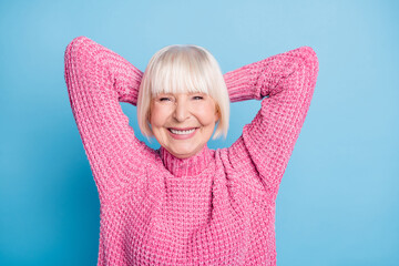 Photo portrait of smiling old lady with two hands behind head taking break isolated on pastel blue colored background