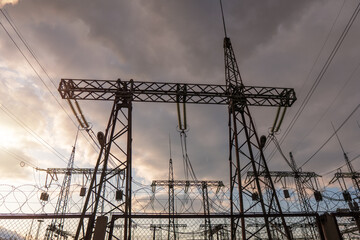 distribution electric substation with power lines silhouette on the dramatic sunset background