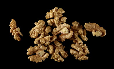 Unshelled walnuts pile isolated on black background with clipping path, top view