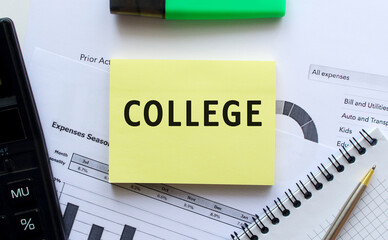 Obraz premium Text COLLEGE on the page of a notepad lying on financial charts on the office desk.