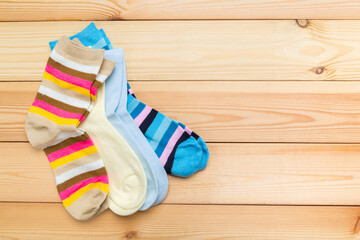 Obraz na płótnie Canvas multicolored new socks in different sizes stacked on a wooden background. clothes for women