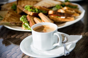 Sandwiches with chicken meat, cheese, cucumber, grilled toasts, and a cup of coffee. Sandwiches and coffee.