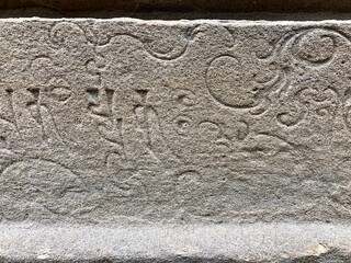 Inscriptions on the ancient temple stone walls. Ancient stone carving. Old stone wall texture. Tamil inscriptions in historical temple walls. Carved inscription in Kanchi Kailasanathar temple.