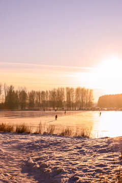 People skate on a frozen lake at sunset. Winter holidays © Mariya Fedorova