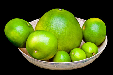 Isolated plate with green citruses fruits. Cutout set of limes, pomelo, grapefruits on black background.