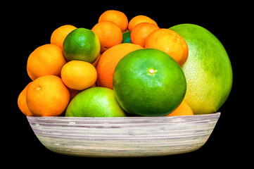 Isolated plate full of citruses fruits. Set of oranges, tangerines, limes, pummelo, grapefruits on black background.