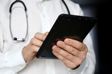 Doctor with a tablet PC in hands. Filling out the medical history