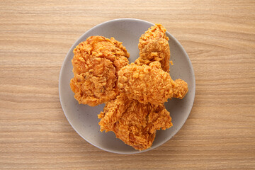 crispy fried chicken in grey dish on wood table
