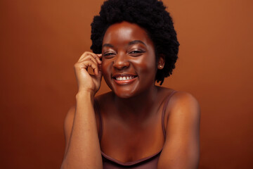 young pretty african model smiling happy on brown background, lifestyle people concept