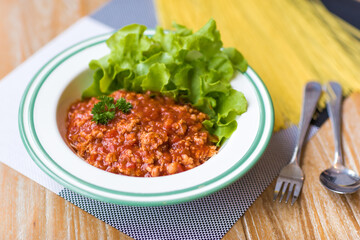 Macaroni, Pork, Tomato and vegetable Served in White Plates on Table with fork and spoon