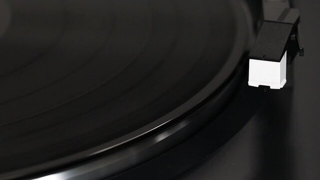Vinyl plate start playing music. Needle move on vinyl plate automatically. Play analog music