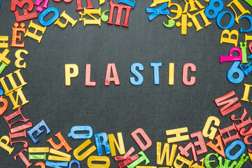 Plastic, word from bright color letters on black background